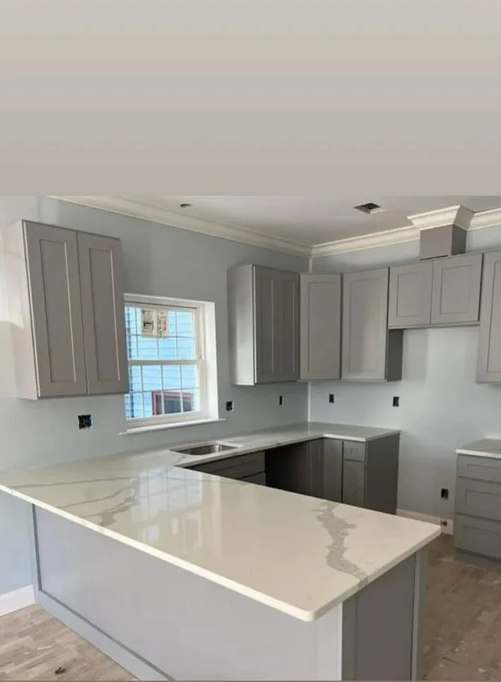 Calacatta quartz peninsula with gray shaker cabinets in a Northern New Jersey kitchen