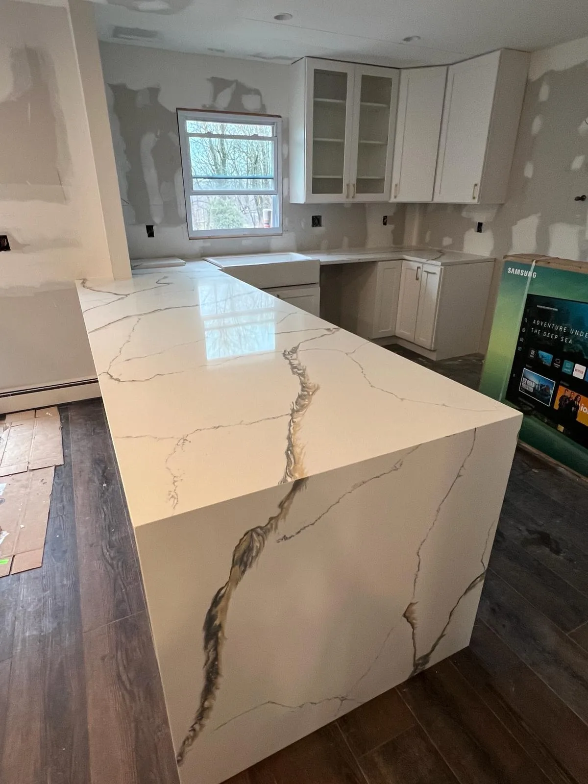 Calacatta quartz waterfall island with dramatic gold and gray veining in a North Jersey kitchen