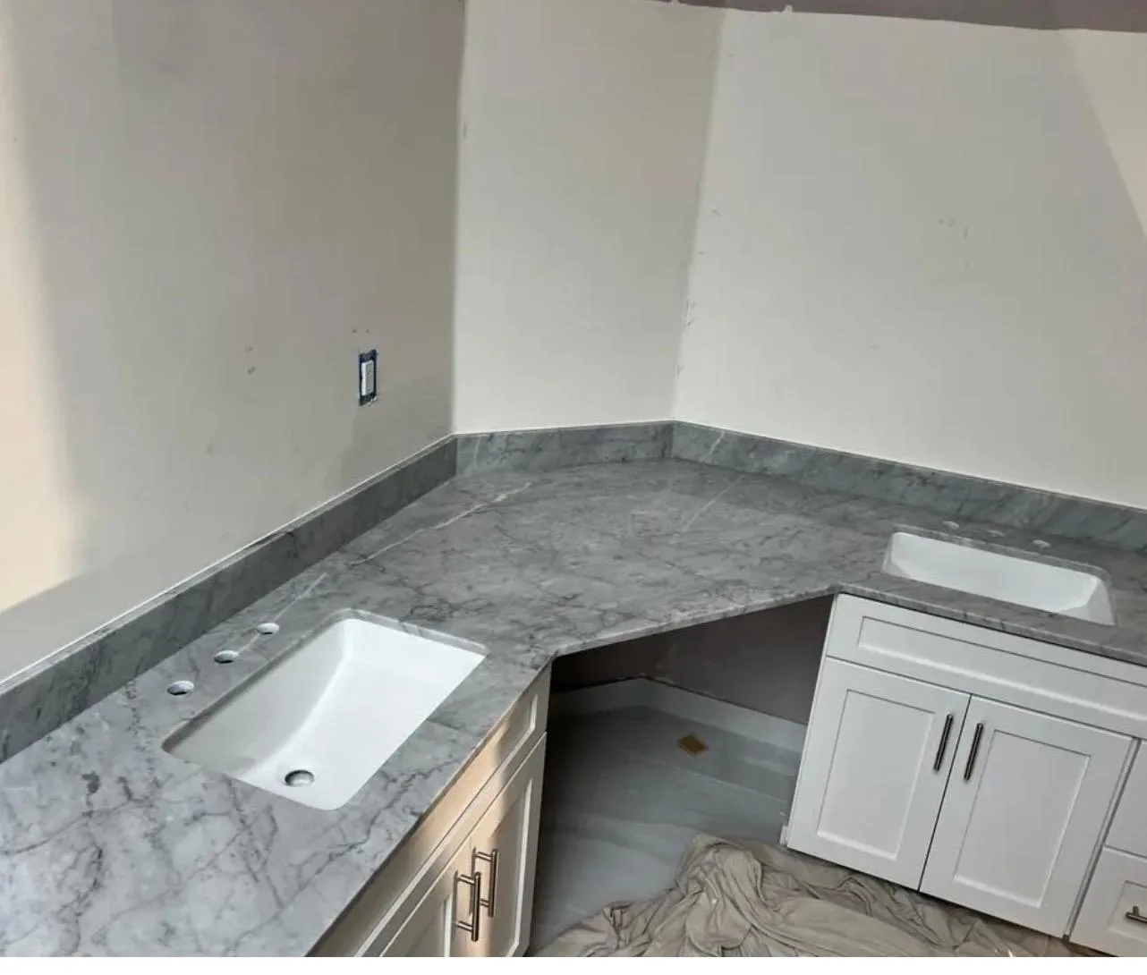 White Carrara marble countertop with fine gray veining and a matching backsplash, fabricated by LG Granite