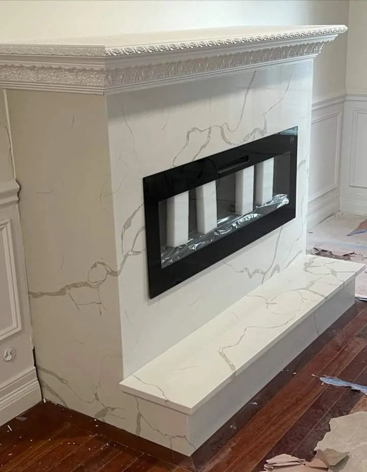 Custom marble fireplace surround with a linear firebox, hand-fabricated by LG Granite & Marble